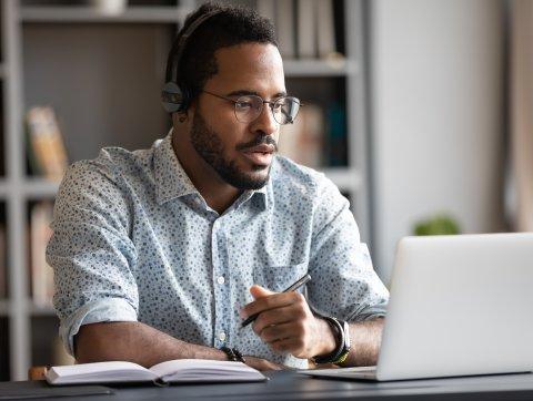 Focused businessman wear headphones study online watching webinar
